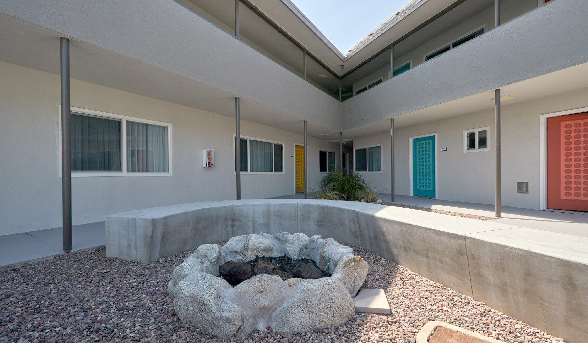A courtyard with a fire pit and colorful doors